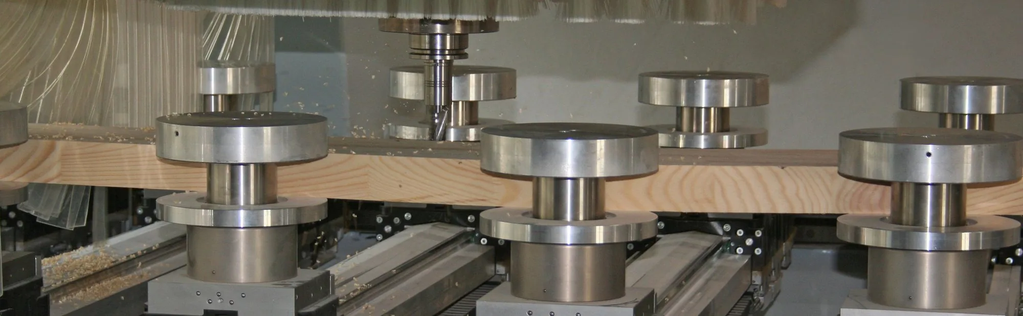 Componentă din lemn fixată pe console cu ventuze într-un utilaj CNC